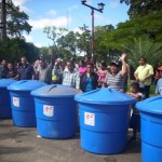 Los vecinos junto al alcalde Gustavo Muñiz reciben tanques de agua